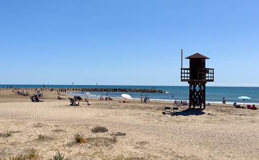 Lifeguard tower on sea beach. Miami Beach with lifeguard tower. Rescue tower with lifeguard to watch swimmers in sea to prevent drowning and danger. Spain beach with rescue tower in Mediterranean