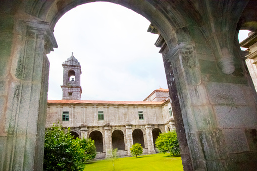 Armenteira monastery church cloister , Meis, Rías Baixas, Pontevedra province, Galicia, Spain, arcade, colonnade, bell tower in the background. Yard garden in the foreground. Copy space on the right.