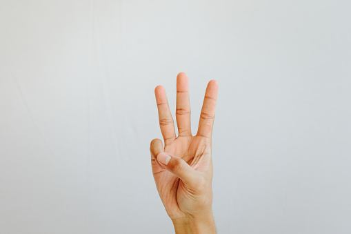 Human hand gesturing numbet three on white background