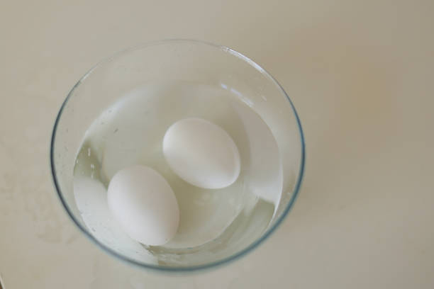 two eggs in water in a transparent bowl