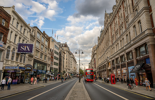 London, UK: The Strand, a major street in central London. With theaters, shops and a red London bus.