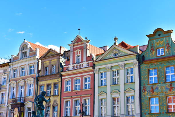 City view of the old buildings with colorful walls and sculpture of a man. Central square, old market with historical buildings.  Poland, Poznan, July 2022