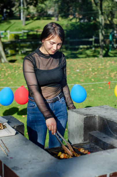 istock young woman cooking on a grill outside 1686801454