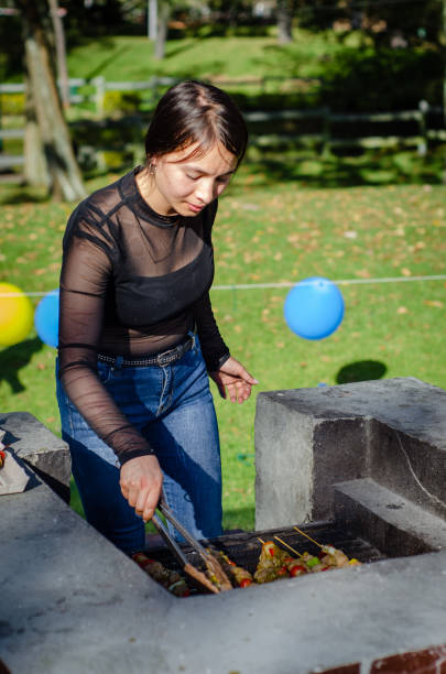 istock young woman cooking on a grill outside 1686801488
