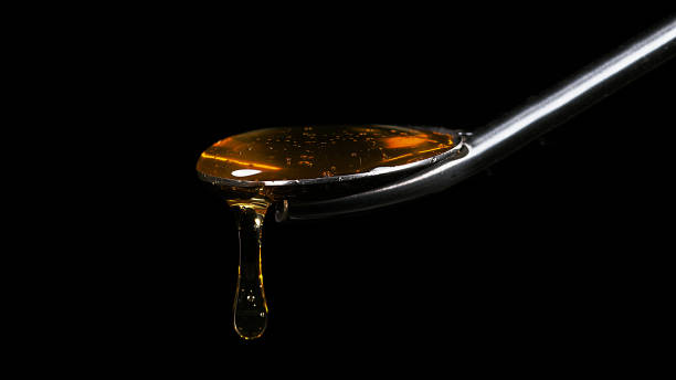 istock Honey Flowing on Spoon against Black Background 1686808944
