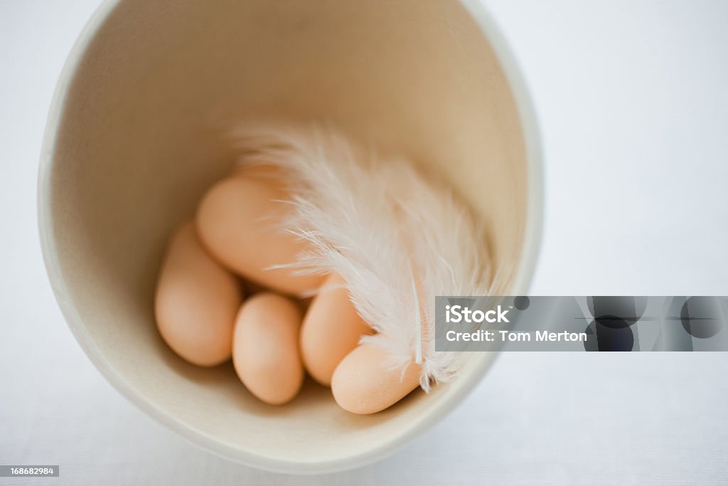 Candy oeuf dans le bol avec des plumes - Photo de Aliments et boissons libre de droits