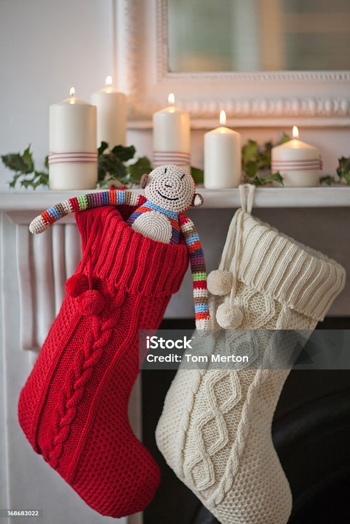 Candles lit on mantelpiece with Christmas stockings  Christmas Stocking Stock Photo