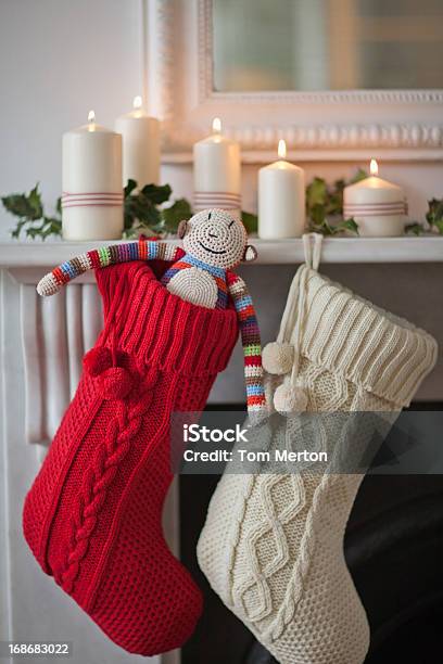 Candles Lit On Mantelpiece With Christmas Stockings Stock Photo - Download Image Now