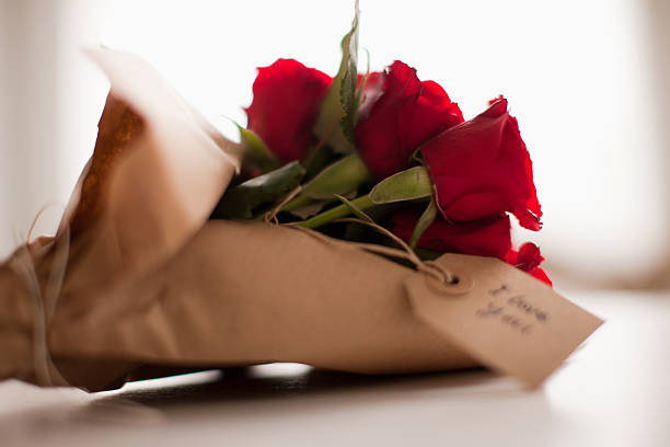detalhe de rosas vermelhas com etiqueta de presente - valentines day gift rose flower - fotografias e filmes do acervo