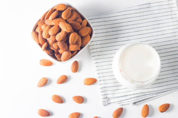 istock Organic almond milk in glass with raw almonds on white table 1686862765
