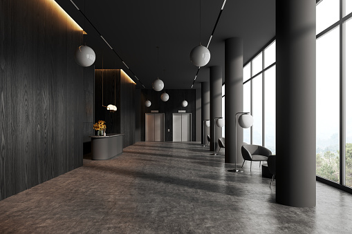 Dark office or hotel interior lobby with armchairs and coffee table, reception desk with elevator. Waiting and meeting space with panoramic window on countryside. 3D rendering