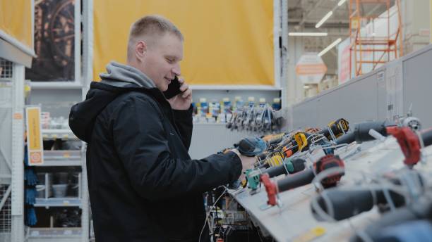 istock Buying a screwdriver at a hardware store. A man in a hardware store buys a power tool. Cordless power tools. Construction equipment supermarket 1686927033