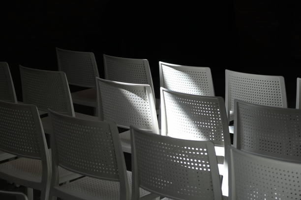 어두운 홀에 있는 하얀 플라스틱 의자 - entrance hall flash 뉴스 사진 이미지