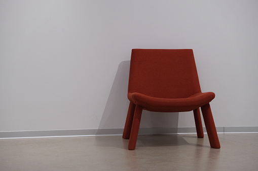 red velvet chair against a white wall