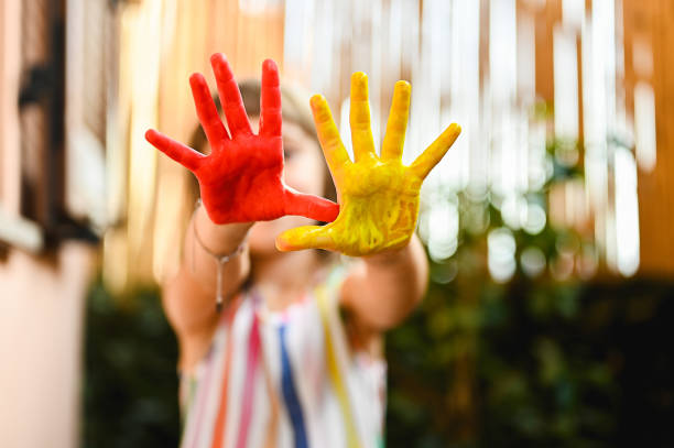 istock little girl showing painted hands. 1686997515