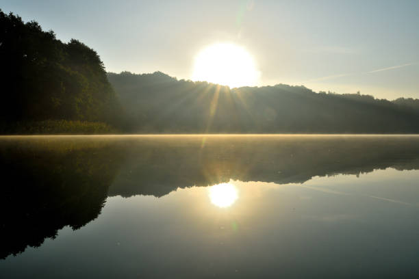 istock lake with mist and sun (sunrise) 1686998136