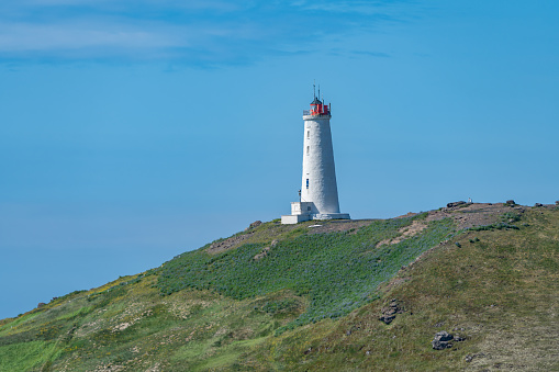 Reykjanes Lighthouse in Iceland, perched on a hill, overlooking the Atlantic Ocean