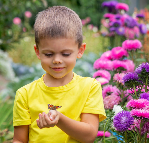 istock boy holding a butterfly on his hand selective focus 1686999730