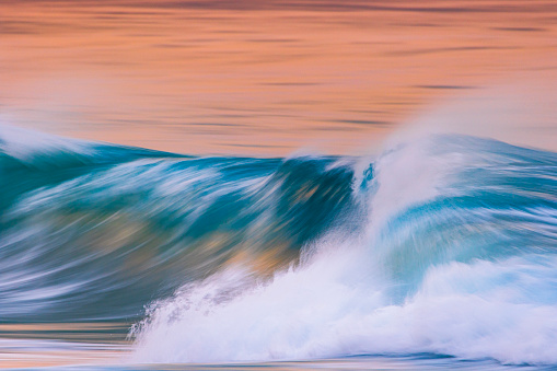 Smooth artistically captured blue ocean wave in golden evening light. Photographed along the coastline of South Western Australia.