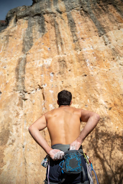 Climber man taking magnesium before climbing outdoors
