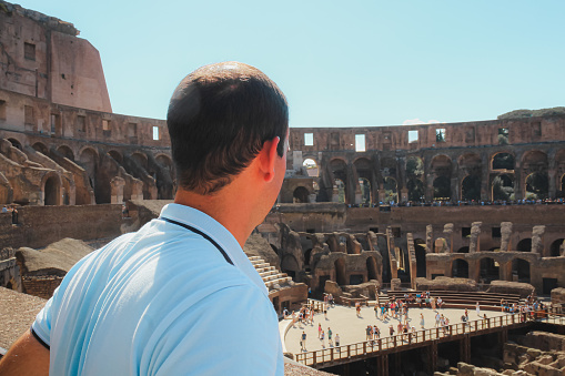 A young man looking towards in sightseeing in the coliseum