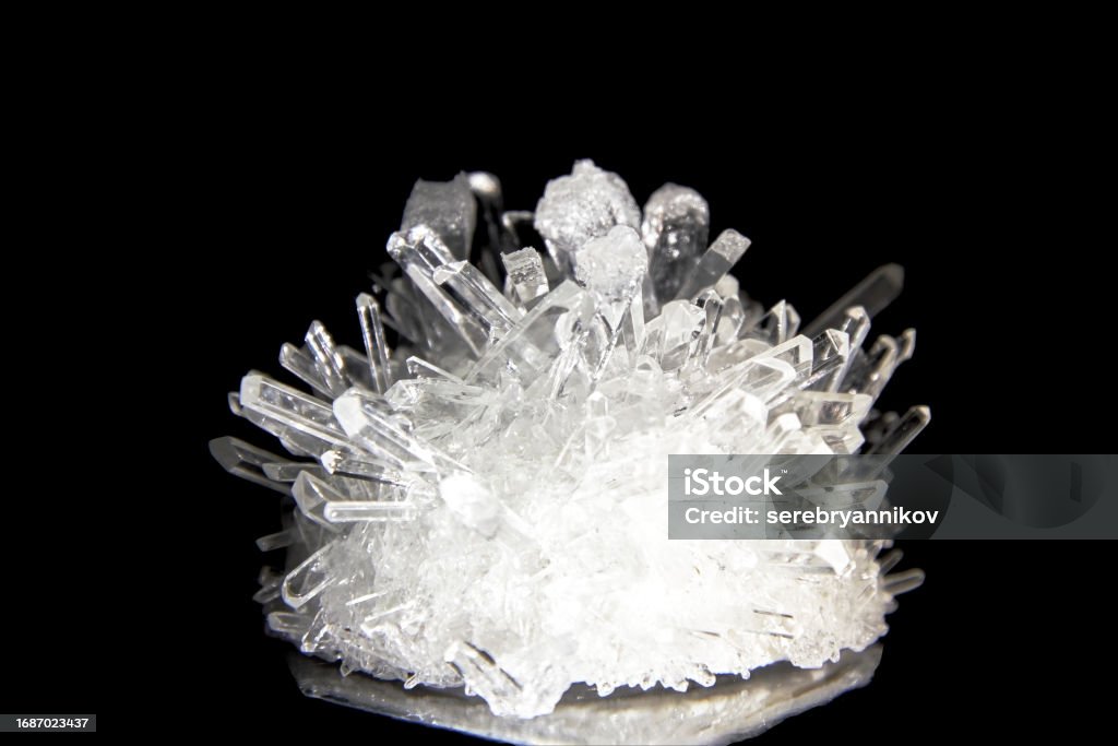 Shiny white sharp quartz crystal highlighted and isolated on black background Shiny white sharp quartz crystal highlighted and isolated on black background. Geology and mineralogy objects. Precious formations Choice Stock Photo