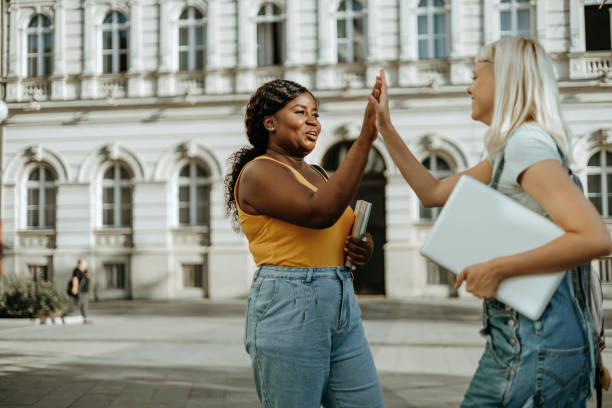 istock Two young female students cheerfully high-fiving 1687036213