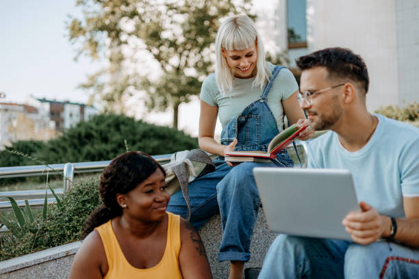 istock A multiracial group of college students sitting outside and working on a group project 1687037314