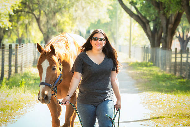 Female Ranch Employee Leading a Horse