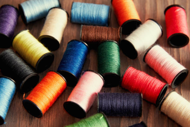 pile of rolls of colorful sewing thread with copy space isolated on white background