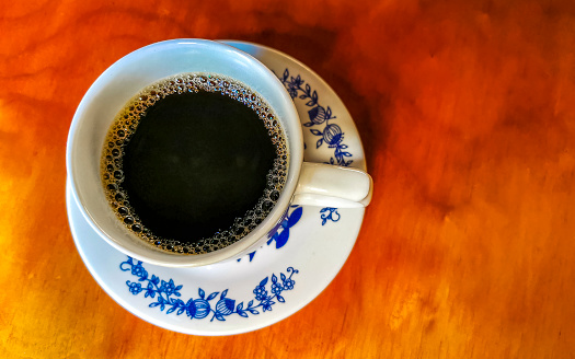 Blue and white cup pot with black coffee americano on wooden table in El Cafecito in Zicatela Puerto Escondido Mexico.