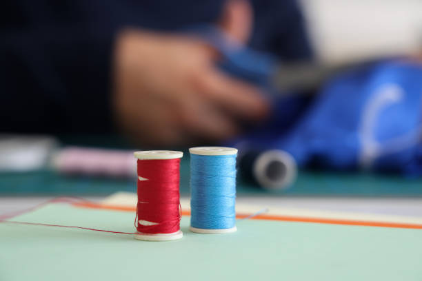 Woman designer is cutting fabric to make products
