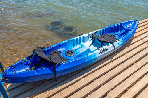 Closeup of blue kayaks on a wooden planks