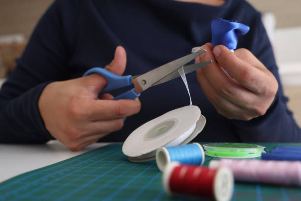 istock Woman designer is cutting fabric to make products 1687055132