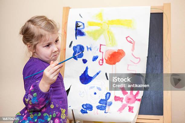 Photo libre de droit de Caucasien Adorable Fille Avec Peinture Brosse À Proximité De Chevalet De Peintre banque d'images et plus d'images libres de droit de 2-3 ans