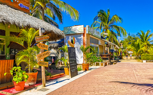 Puerto Escondido Oaxaca Mexico 27. January 2023 Typical beautiful colorful tourist street road and sidewalk with city life cars traffic buildings hotels bars restaurants and people in Zicatela Mexico.