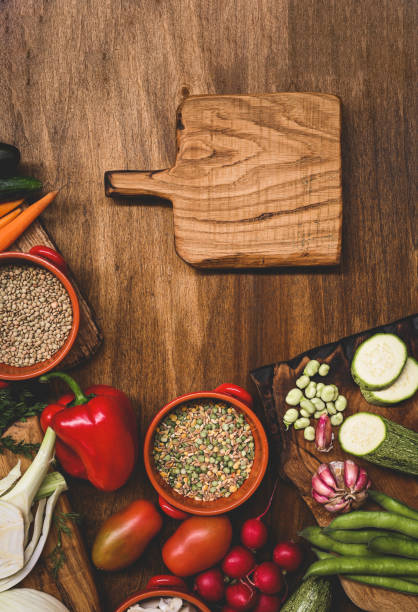 istock fresh vegetables on rustic wooden table with empty wooden cutting board. 1687095853
