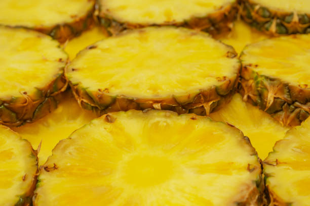 Pineapple juicy yellow slices as a background. Top view.