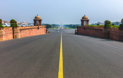 Rajpath is the main road, thoroughfare, between the Houses of Parliament and India Gate (seen on the horizon) in Delhi, India. The shot was taken on a bright sunny morning with blue sky.