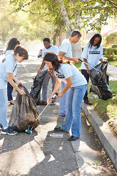 une équipe de volontaires soulever litière dans la rue - bag garbage bag plastic black photos et images de collection