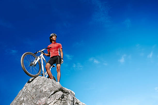 Mountain biker resting before downhill and looking in sunset