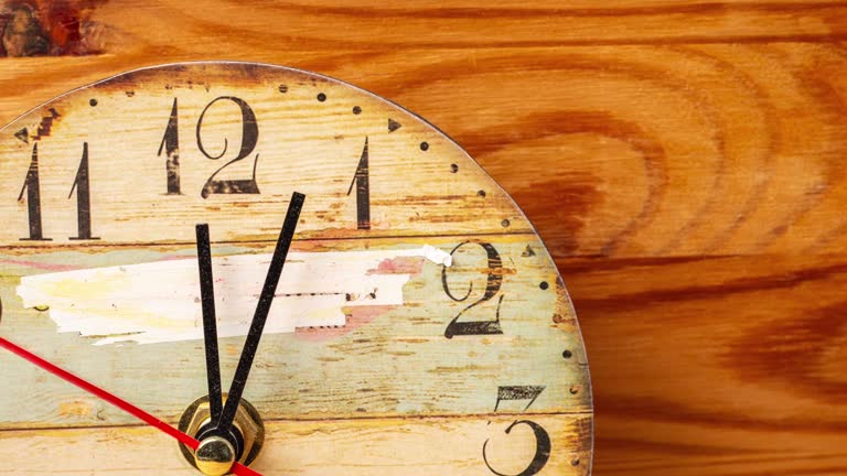 Time lapse clock on wooden background.