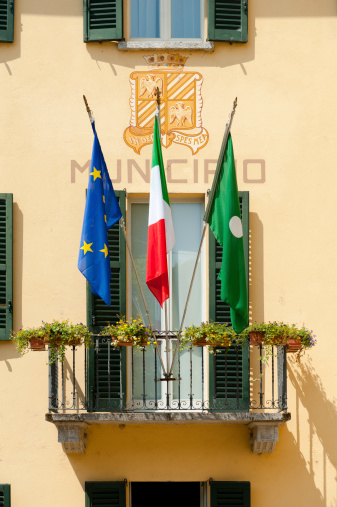 Close-up shot of a european, italian and local flag of Bellagio at the local townhall.