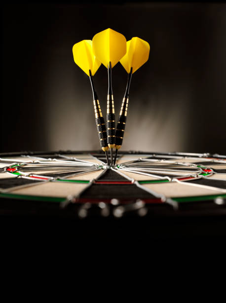 Copy Space in Darts Three yellow darts hitting the target in a game of darts scoring a bulls eye. Copy space dart photos stock pictures, royalty-free photos & images