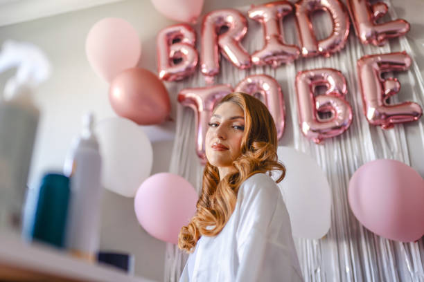 istock Young bride's make-up and hair being done on her wedding day 1687149918