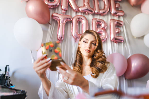 istock Young bride's make-up and hair being done on her wedding day 1687151842