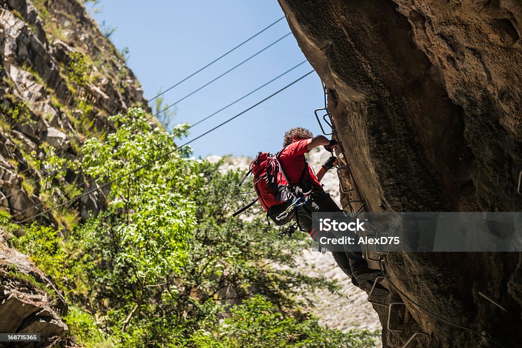 Climber on a Via Ferrata Man climbing cliff on a via ferrata (klettersteig) Dolomites Stock Photo