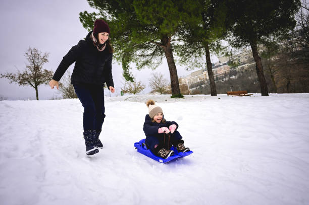 istock family having fun sledding down the hill. 1687178444