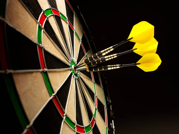 bulls olho amarelos em um alvo de dardo com dardos - bulls eye dart target dartboard imagens e fotografias de stock