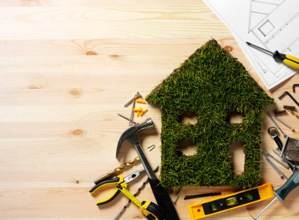 Grass Environment House Eco house cut out of grass with construction tools and copy space on a wooden background. work tool nail wood construction stock pictures, royalty-free photos & images